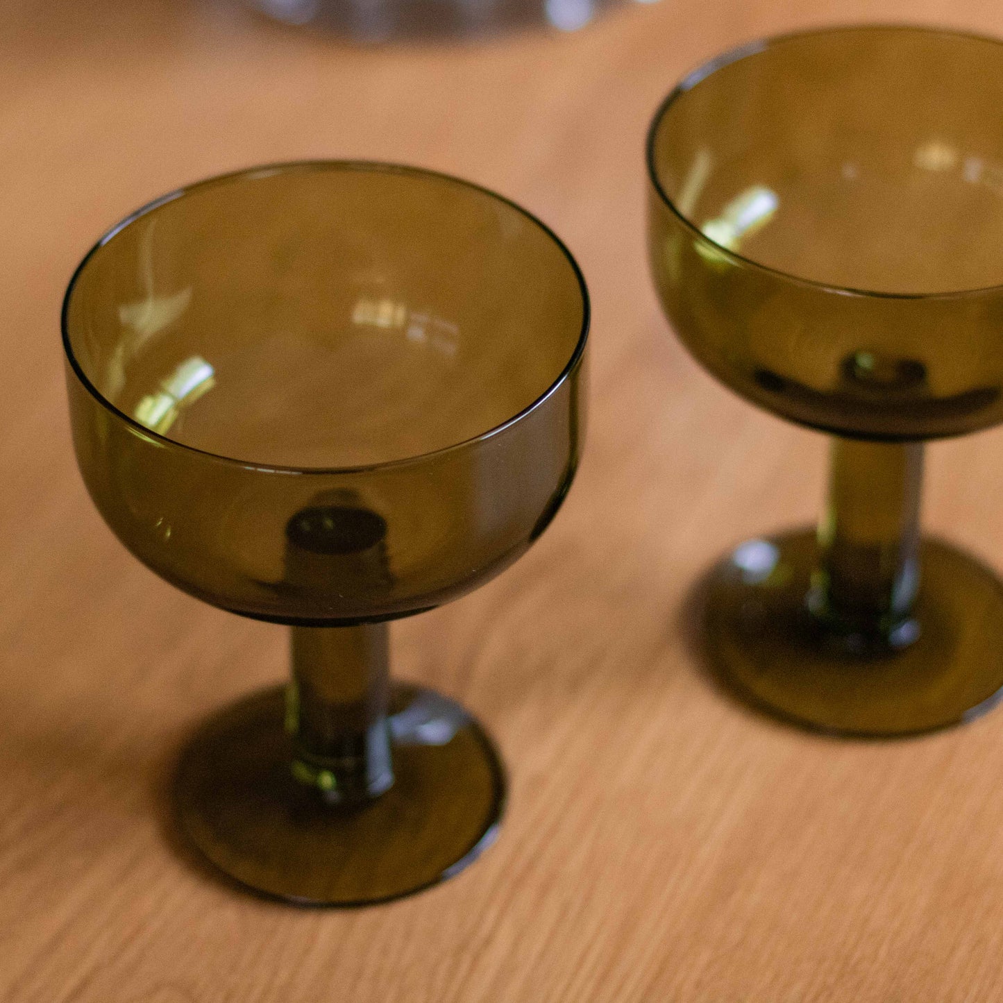 Shop our set of 2 olive green coupe glasses. Perfect for cocktails, champagne, spritzes, desserts and colourful table styling.