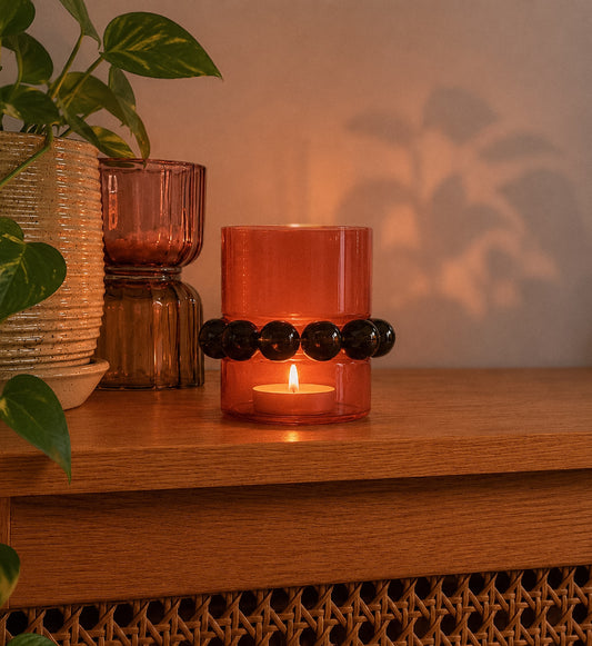 Shop our rust glass candle holder with dark beaded detail. A warm, retro home decor piece for shelves, tables and cosy styling.